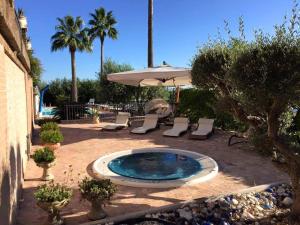a pool with chairs and an umbrella on a patio at Le Palme Residenza Estiva in Martinsicuro