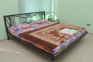 Una cama con edredón en un dormitorio en Purvaj Vastalya, en Kolhapur