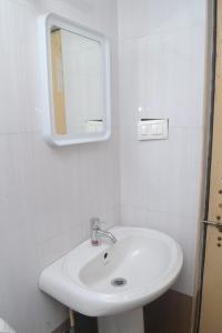 y baño con lavabo blanco y espejo. en Purvaj Vastalya, en Kolhapur