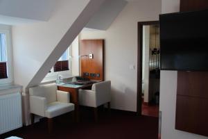 Habitación con escritorio y 2 sillas blancas. en Adena Hotel, en Bremerhaven