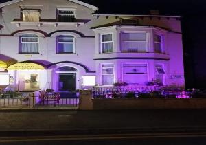 a white house with purple lighting in front of it at Berkswell Holiday Apartments in Blackpool