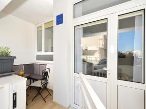 une porte coulissante en verre dans une chambre avec une table dans l'établissement Apartment Arya, à Makarska