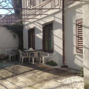 une table et des chaises assises à l'extérieur d'un bâtiment dans l'établissement G.VERGA 22, à Trieste