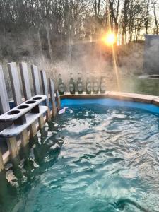 a pool of water with a bench and a hot tub at The Lodge in Borre