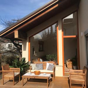 eine Terrasse mit einem Sofa, einem Tisch und Stühlen in der Unterkunft Klinar - Cosy apartment with a terrace in Bled