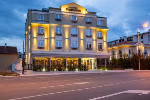 a hotel with a lit up facade on a street at Hotel Resurs in Podgorica