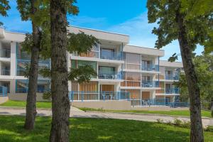 an apartment building with trees in front of it at Hotel Forest Beach in Primorsko