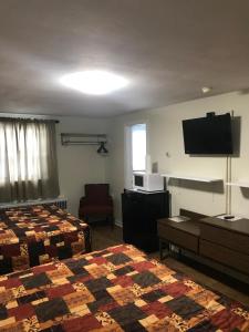 a hotel room with two beds and a flat screen tv at Evergreen Motel in Oswego