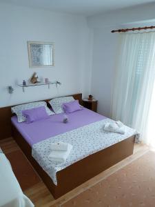 a bedroom with a purple bed with purple pillows at Apartman Kristin in Podaca