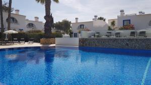 a large blue swimming pool in front of a building at Pestana Palm Gardens in Carvoeiro