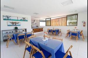 a dining room with blue tables and chairs at Muro Alto Flat Nui Supreme in Porto De Galinhas
