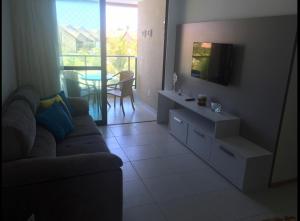 a living room with a couch and a tv at Muro Alto Flat Nui Supreme in Porto De Galinhas