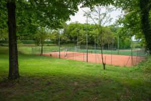 a tennis court with a lot of trees at Borgo San Luigi in Monteriggioni