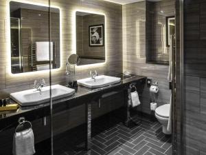 a bathroom with two sinks and a toilet at Hotel Gotham in Manchester