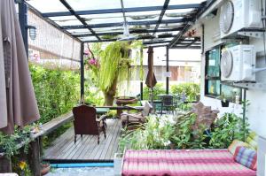 an outdoor deck with a pergola and a table and chairs at Early Bird Hostel Ayutthaya in Phra Nakhon Si Ayutthaya
