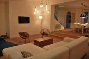 a living room with a couch and chairs and a table at Maison de village, charme scandinave in Carantec