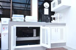 a white cabinet with a microwave inside of it at Early Bird Hostel Ayutthaya in Phra Nakhon Si Ayutthaya
