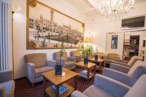 a waiting room with chairs and tables and a painting on the wall at Hotel The Lord in Ghent