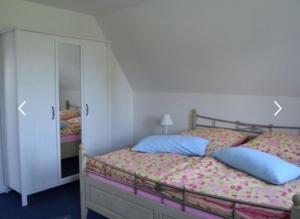 una camera con letto, 2 cuscini e armadio di Frische Brise a Ditzum