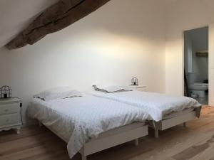 ein weißes Schlafzimmer mit einem Bett und einem Badezimmer in der Unterkunft Gîte de charme Les Trois Chênes in Augères