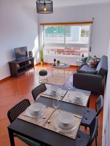 a dining table and chairs in a living room at Quinta dos Arcos Feel At Home in Armação de Pêra