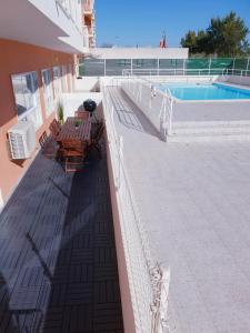 a balcony with two benches and a swimming pool at Quinta dos Arcos Feel At Home in Armação de Pêra