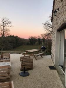 ein Picknicktisch und ein Grill neben einem Gebäude in der Unterkunft Gîte de charme Les Trois Chênes in Augères