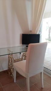 a white chair sitting in front of a glass desk at NN room near the Athens airport in Spáta