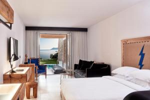 a bedroom with a bed and a living room at Myconian Imperial - Leading Hotels of the World in Elia Beach