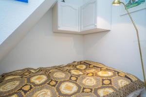 Ce lit se trouve dans un dortoir doté d'une lampe à côté d'un escalier. dans l'établissement Watthüs OG, à Morsum