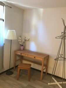 Cette chambre dispose d'un bureau en bois et d'une lampe. dans l'établissement Gîte aux deux Hameaux, à Saint-Pierre-Bois