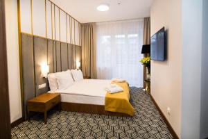 a hotel room with a bed with a yellow blanket on it at Platinum Residence Boutique in Poznań