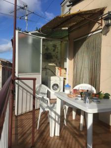 un balcon avec une table et des chaises ainsi qu'un lave-linge. dans l'établissement Casa Salvaggio, à Grotte