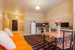a living room with a table and a kitchen at Pechersk House in Kyiv