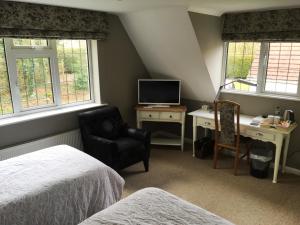 een slaapkamer met een bureau, een bed en een stoel bij The Beeches Bed and Breakfast in Hinckley