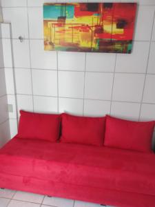 a red couch with red pillows in a room at Edf. Iracema Costa in Recife