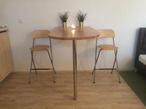 a table with two chairs and a table with two plants on it at Dragonfly in Brno