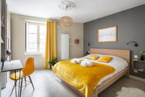 ein Schlafzimmer mit einem großen Bett und einer gelben Decke in der Unterkunft LE CRAZY by Cocoonr in Rennes