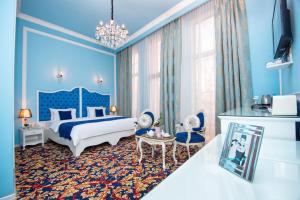 Dormitorio azul con cama y ventana grande en River Side Hotel Tbilisi, en Tiflis