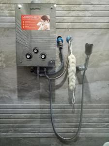 a shower with a hose hooked up to a machine at Homestay Syariah Cileunyi, Bandung Timur in Bandung