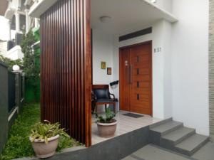 een toegang tot een huis met een houten deur bij Homestay Syariah Cileunyi, Bandung Timur in Bandung