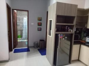 een keuken met een koelkast en een deur naar een kamer bij Homestay Syariah Cileunyi, Bandung Timur in Bandung