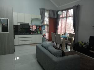 een woonkamer met een bank en een tafel en een keuken bij Homestay Syariah Cileunyi, Bandung Timur in Bandung