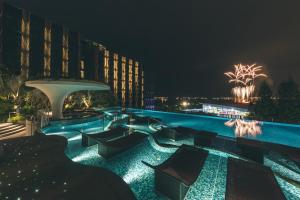 a resort with a pool at night at Village Hotel Sentosa by Far East Hospitality in Singapore
