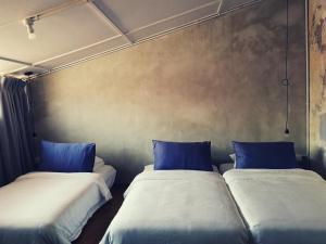 two beds in a room with blue pillows at LEJU 8 樂居 Loft living with open air bathroom in Melaka