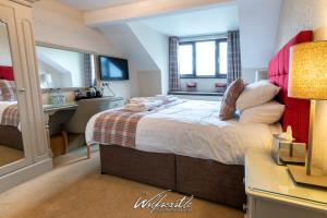 a hotel room with two beds and a television at Wolfscastle Country Hotel in Treffgarne