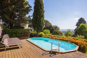 - une piscine sur une terrasse en bois avec 2 chaises longues dans l'établissement Villa Acacia, à Florence