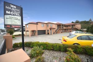 a yellow car parked in a parking lot with a no vacancy sign at 166 Majestic Court Motel in Christchurch