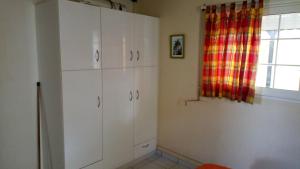 una cocina con armarios blancos y una ventana en Gites VASSEAUX, en Capesterre-Belle-Eau