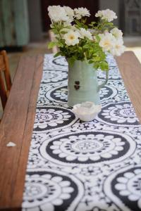 une table avec un vase et des fleurs sur lui dans l'établissement Dancing River Guesthouse, à Vereeniging